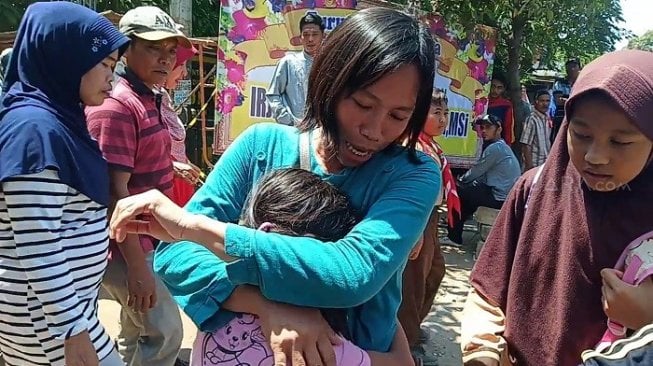 Naila, korban insiden ambruknya atap SDN Getong menangis sambil memeluk erat ibunya. (Suara.com/Achmad Ali).