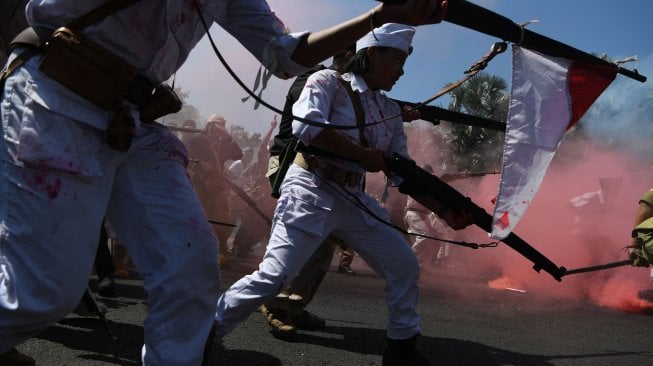 Peserta parade menampilkan aksi teatrikal pertempuran pejuang Indonesia melawan pasukan Inggris saat Parade Surabaya Juang di depan Gedung Negara Grahadi, Surabaya, Jawa Timur, Sabtu (9/11). [ANTARA FOTO/Zabur Karuru]