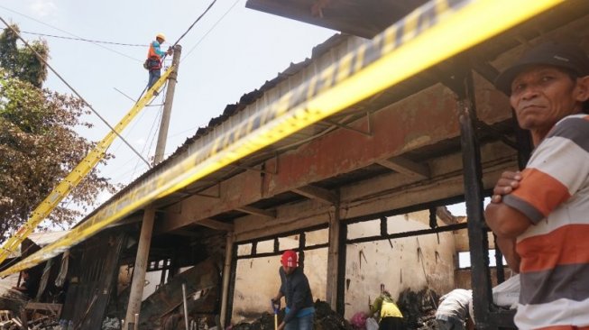 Sejumlah pedagang nekat menerobos garis polisi untuk melihat kios miliknya yang hangus terbakar menyisakan puing kehancuran di dalam kompleks Pasar Ngunut, Tulungagung, Jawa Timur, Sabtu (9/11/2019). (ANTARA FOTO/Destyan Sujarwoko)