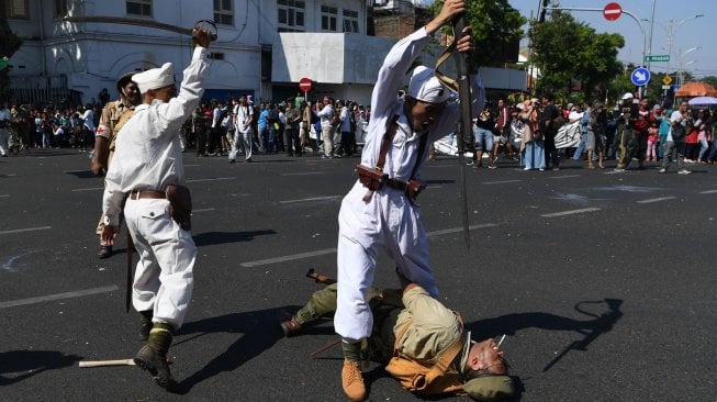 Peserta parade menampilkan aksi teatrikal pertempuran pejuang Indonesia melawan pasukan Inggris saat Parade Surabaya Juang di Jalan Tunjungan, Surabaya, Jawa Timur, Sabtu (9/11). [ANTARA FOTO/Zabur Karuru]