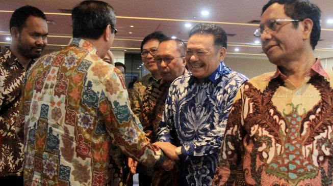 Ketua Dewan Pembina Perhimpunan Advokat Indonesia Otto Hasibuan berjabat tangan dengan Menteri Hukum dan Hak Asasi Manusia Yasonna Laoly saat menghadiri acara syukuran Menkopolhukam Mahfud MD di Kementerian Hukum dan Ham, Jakarta, Minggu (10/11). [Suara.com/Oke Atmaja]