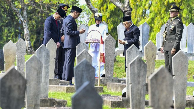 Presiden Joko Widodo (kedua kiri) bersama Wakil Presiden Ma'ruf Amin (kedua kanan) dan Menteri Sosial Juliari Batubara (kiri) berdoa bersama setelah melakukan tabur bunga usai Upacara Ziarah Nasional di Taman Makam Pahlawan Nasional Utama Kalibata, Jakarta, Minggu (10/11). [ANTARA FOTO/Galih Pradipta]