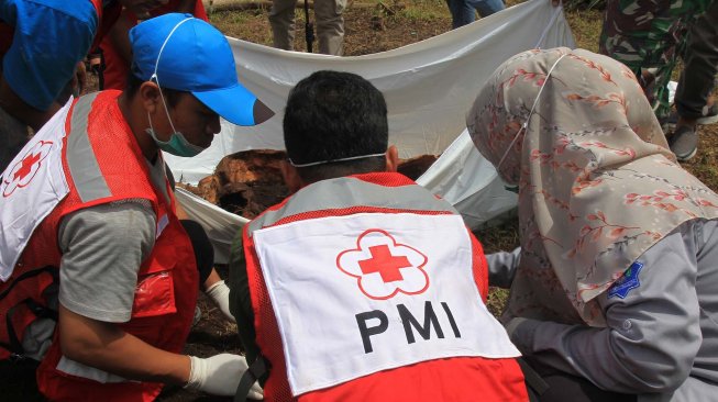 Petugas Palang Merah Indonesia (PMI) Aceh Barat bersama masyarakat mengevakuasi jenazah yang terbungkus kantong plastik yang diduga korban Tsunami Aceh 26 Desember 2004 dikawasan lahan pertanian warga Desa Suak Nie, Kecamatan Johan Pahlawan, Aceh Barat, Aceh, Minggu (10/11).  [ANTARA FOTO/Syifa Yulinnas]