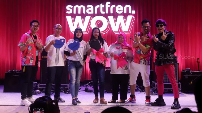 Chief Brand Officer Smartfren Roberto Saputra (paling kiri) dan Deputy CEO Smartfren Djoko Tata Ibrahim (kedua kanan), bersama para pemenang Undian Smartfren WOW tahap kedua di Ecovention Ancol, Jakarta, Minggu (10/11). [Suara.com/Angga Budhiyanto]
