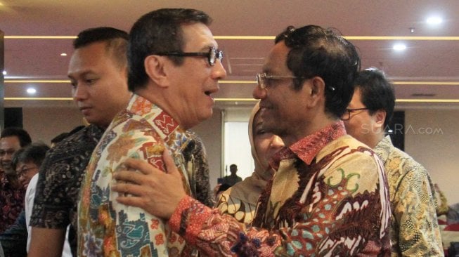 Menteri Hukum dan Hak Asasi Manusia Yasonna Laoly memeluk Menkopolhukam Mahfud MD saat menghadiri acara syukuran di Kementrian Hukum dan Ham, Jakarta, Minggu (10/11). [Suara.com/Oke Atmaja]