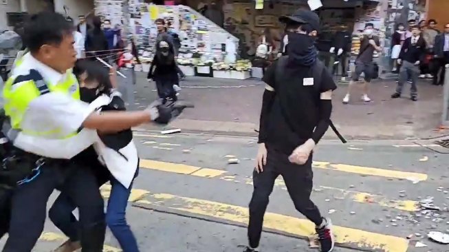 Polisi menembak seorang demonstran prodemokrasi saat terjadi protes di Distrik Sai Wan Ho, Hong Kong, Senin (11/11). [LAURENT FIEVET/CUPID NEWS/AFP]