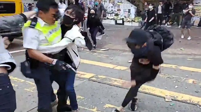 Polisi menembak seorang demonstran prodemokrasi saat terjadi protes di Distrik Sai Wan Ho, Hong Kong, Senin (11/11). [LAURENT FIEVET/CUPID NEWS/AFP]