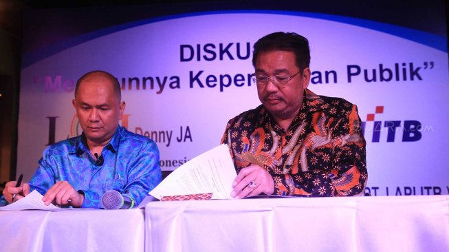 Pengurus Lembaga Afiliasi Penelitian Indonesia - Institut Teknologi Bandung (LAPI ITB) Donald C Lantu (kiri) dan Denny JA berfoto melakukan penandatanganan kerja sama kedua lembaga itu di Jakarta, Rabu (13/11). [Suara.com/Oke Atmaja]