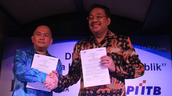 Pengurus Lembaga Afiliasi Penelitian Indonesia - Institut Teknologi Bandung (LAPI ITB) Donald C Lantu (kiri) dan Denny JA berfoto melakukan penandatanganan kerja sama kedua lembaga itu di Jakarta, Rabu (13/11). [Suara.com/Oke Atmaja]