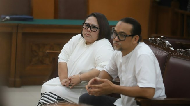 Comedian Tri Retno Prayudati alias Nunung with her husband July Jan Sambiran undergo a trial reading the demands at the South Jakarta District Court, Wednesday (13/11). [Suara.com/Arya Manggala]
