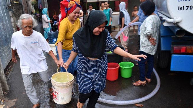 Warga antre mendapatkan air bersih dari mobil tanki air di Cipayung, Jakarta Timur, Rabu (13/11). [ANTARA FOTO/Sigid Kurniawan]