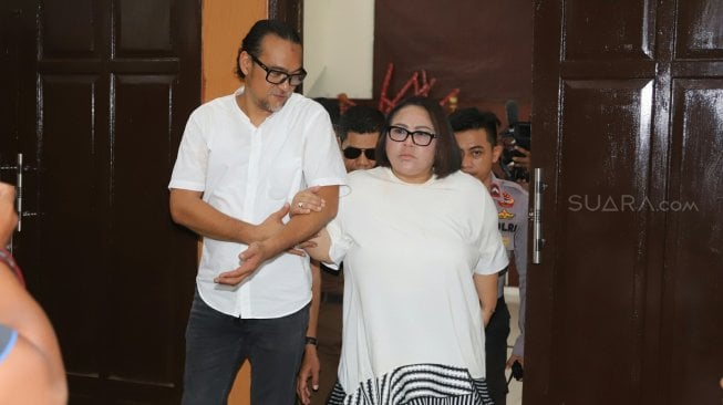 Comedian Tri Retno Prayudati alias Nunung with her husband July Jan Sambiran prepares to undergo a trial reading the demands at the South Jakarta District Court, Wednesday (13/11). [Suara.com/Arya Manggala]