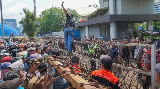 Ratusan warga yang berasal dari Desa Slarang, Kecamatan Kesugihan, Kabupaten Cilacap menjalani aksi menyerukan pencemaran lingkungan yang timbul akibat Pembangkit Listrik Tenaga Uap (PLTU) Cilacap PT Sumber Segara Primadaya (S2P), Kabupaten Cilacap, Kamis (14/11/2019). (Suara.com/Anang)