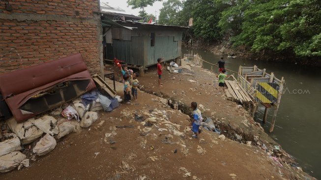 Warga beraktivitas di bantaran Sungai Ciliwung, Kampung Tanah Rendah, Jakarta, Kamis (14/11). [Suara.com/Angga Budhiyanto]