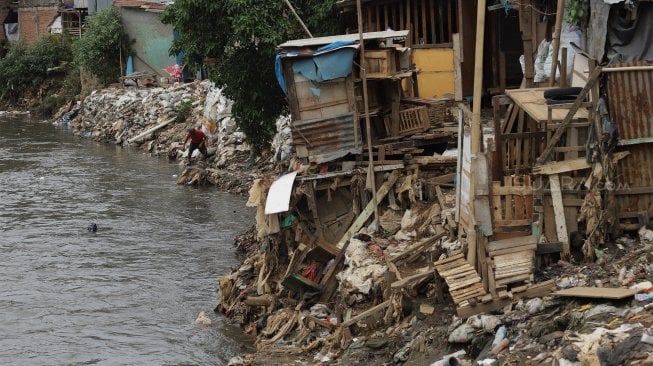 Warga beraktivitas di bantaran Sungai Ciliwung, Kampung Tanah Rendah, Jakarta, Kamis (14/11). [Suara.com/Angga Budhiyanto]