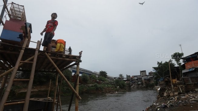 Warga beraktivitas di bantaran Sungai Ciliwung, Kampung Tanah Rendah, Jakarta, Kamis (14/11). [Suara.com/Angga Budhiyanto]