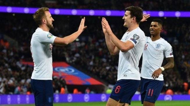 Striker Inggris Harry Kane (kiri) merayakan golnya dengan rekan setimnya Harry Maguire dan Marcus Rashford saat mengalahkan Montenegro di Wembley Stadium pada kualifikasi Piala Eropa 2020. Glyn KIRK / AFP