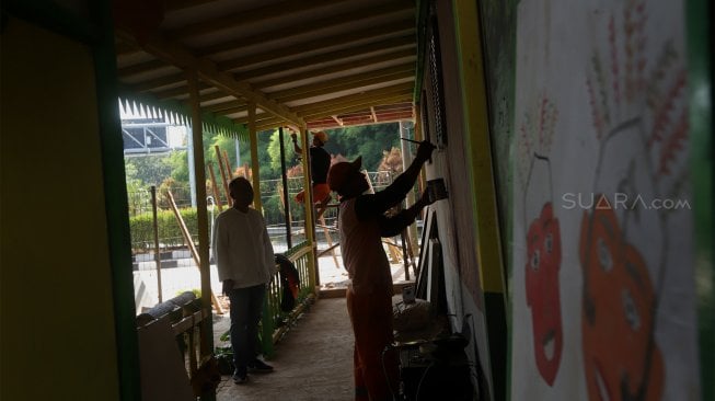 Petugas PPSU menyelesaikan pembangunan Taman Budaya Betawi di Kolong Tol JORR W2 Joglo, Kembangan, Jakarta Barat, Jumat (15/11). [Suara.com/Angga Budhiyanto]