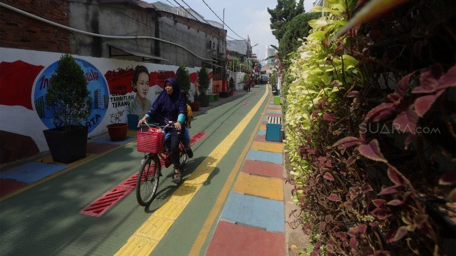 Warga beraktivitas di Kampung Budaya, Jalan Katalia 1 Timur, Jakarta Barat, Jumat (15/11). [Suara.com/Angga Budhiyanto]