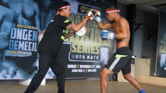 Petinju Indonesia Daud Yordan (kanan) melakukan latihan jelang pertandingan di Batu, Jawa Timur, Jumat (15/11/2019), bersama sang kakak Damianus Yordan. [Antara/Ari Bowo Sucipto]