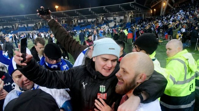 Fan Finlandia nampak mengajak foto Teemu Pukki usai memastikan negaranya lolos ke Piala Eropa 2020. (The Sun/AP:Associated Press)