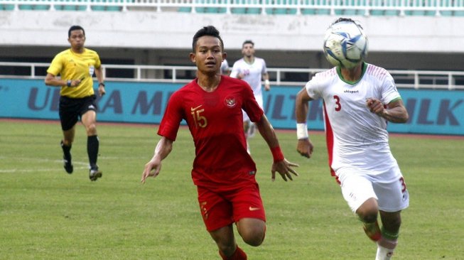 Pesepak bola timnas U-23 Indonesia Sani Rizki Fauzi (kiri) berebut bola dengan pesepak bola timnas U-23 Iran Mohammad Mioslemipour dalam laga persahabatan di Stadion Pakansari, Cibinong, Bogor, Jawa Barat, Sabtu (16/11/2019). ANTARA FOTO/Yulius Satria Wijaya/aww.