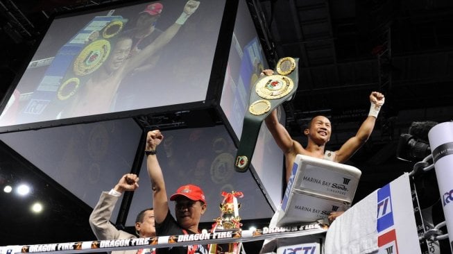 Petinju Indonesia, Daud Yordan (kanan), merayakan keberhasilannya menjadi juara dunia kelas bulu IBO usai mengalahkan Lorenzo Villanueva (Filipina) di Marina Bay Sands Hotel, Singapura, Sabtu (5/5/2012). [AFP/Simin Wang]