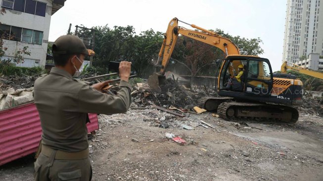 Petugas dengan alat berat membongkar bangunan liar di kawasan Sunter, Jakarta, Senin (18/11). [Suara.com/Arya Manggala]