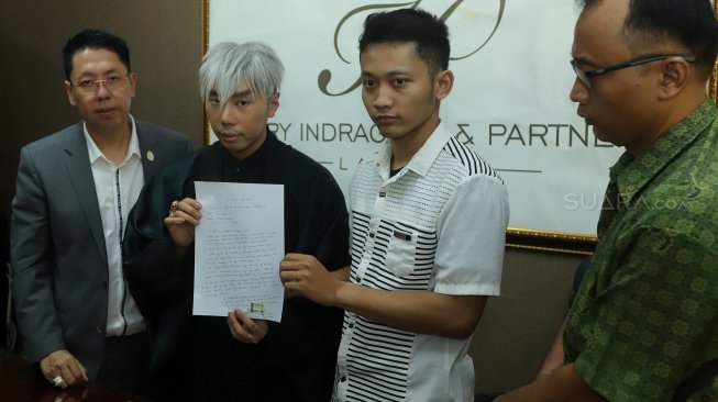 Presenter sekaligus paranormal Roy Kiyoshi (tengah) didampingi Henry Indraguna (kiri) dan pemilik akun YouTube Hikmah Kehidupan Abriel (kanan) menujukkan surat kesepakatan perdamaian di kantor pengacara Henry Indraguna, Belleza Permata Hijau, Jakarta, Selasa (19/11). [Suara.com/Angga Budhiyanto]   