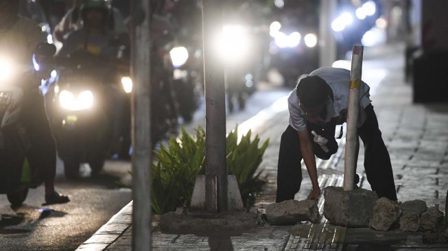 Seorang warga, Arif menata batu di trotoar untuk menghalau sepeda motor di Jalan Menteng Raya, Jakarta, Senin (18/11). [ANTARA FOTO/Wahyu Putro]