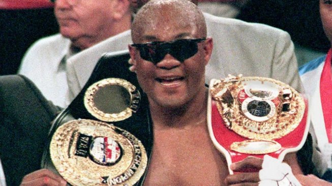 George Foreman merayakan keberhasilannya menjadi juara dunia kelas berat IBF dan WBU usai mengalahkan Axel Schulz (Jerman), Sabtu (22/4/1995]. [AFP/Jeff Haynes]