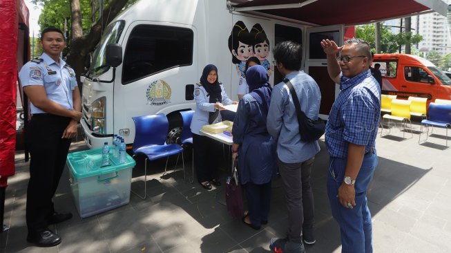 Petugas imigrasi melayani pemohon pembuat passport saat pelayanan passport keliling di Plaza Semanggi, Jakarta, Selasa (19/11). [Suara.com/Angga Budhiyanto]