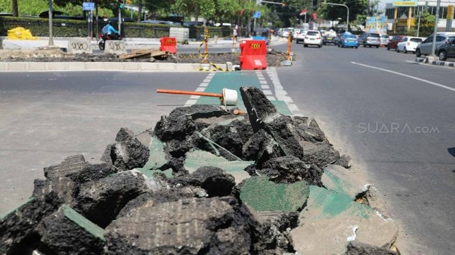 Pengguna jalan melintas di samping jalur sepeda yang dibongkar di kawasan Cikini, Jakarta, Selasa (19/11). [Suara.com/Arya Manggala]