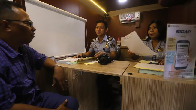 Petugas imigrasi melayani pemohon pembuat passport saat pelayanan passport keliling di Plaza Semanggi, Jakarta, Selasa (19/11). [Suara.com/Angga Budhiyanto]