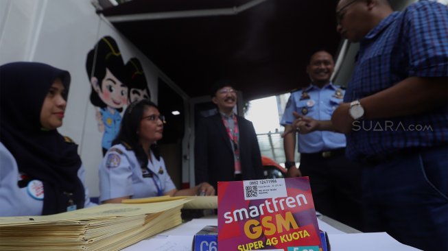 Marco Sumampow, Direktur Smartfren (tengah) bersama Alvian Bayu, Kepala Seksi Infokim Kantor Imigrasi Kelas 1 Non TPI Jakarta Pusat (kedua kanan) berbincang dengan masyarakat yang sedang mengurus passport di Plaza Semanggi, Jakarta, Selasa (19/11). [Suara.com/Angga Budhyanto]
