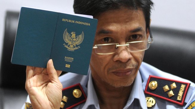 Kepala Kantor Imigrasi Kelas I Khusus Ngurah Rai Amran Aris menunjukkan Paspor Elektronik (e-passport) saat penerbitan Paspor Elektronik perdana di Badung, Bali, Rabu (20/11). [ANTARA FOTO/Fikri Yusuf]