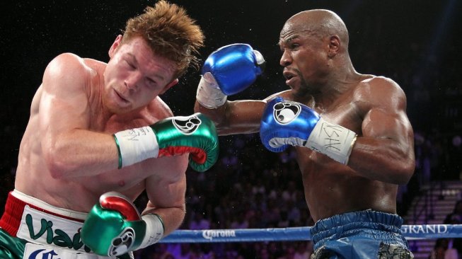 Petinju Meksiko, Saul Alvarez (kiri), saat menghadapi legenda tinju dunia Floyd Mayweather Jr. di T-Mobile Arena, Las Vegas, AS pada, Sabtu (14/9/2013). [AFP/John Gurzinski]