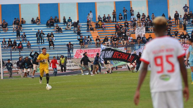 Suporter LA Mania melakukan aksi bakar-bakar dan merusak papan skor setelah eksekusi pinalti Pemain Persela, Alex Dos Santos digagalkan kiper Perseru Badak Lampung FC, Daryono dalam pertandingan Liga 1 2019 di Stadion Surajaya Lamongan, Jawa Timur, Rabu (20/11). [ANTARA FOTO/Syaiful Arif]