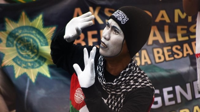 Seorang guru Ponpes Persatuan Islam (Persis) memainkan pantomim saat aksi Solidaritas Untuk Warga Palestina di Alun-alun Serang, Banten, Jumat (22/11). [ANTARA FOTO/Asep Fathulrahman]