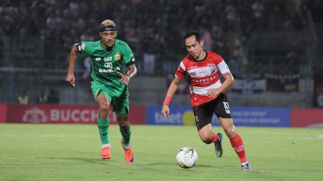 Pesepak bola Madura United (MU) Slamet Nurcahyo (kanan) menggiring bola dibayangi pesepak bola Bhayangkara Fc Bruno Matos (kiri) dalam laga Shopee Liga 1 di Stadion Gelora Bangkalan (SGB) Bangkalan, Jawa Timur, Jumat (22/11/2019). Bhayangkara FC memenangi pertandingan tersebut dengan skor 2-1. ANTARA FOTO/Saiful Bahri