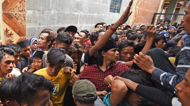 Ratusan warga antre menunggu pembagian sedekah saat acara Panjang Mulud di Kampung Tanggul, Serang, Banten, Sabtu (23/11). [ANTARA FOTO/Asep Fathulrahman]