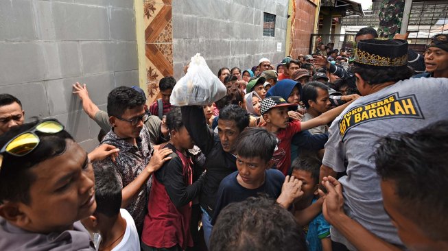 Ratusan warga antre menunggu pembagian sedekah saat acara Panjang Mulud di Kampung Tanggul, Serang, Banten, Sabtu (23/11). [ANTARA FOTO/Asep Fathulrahman]