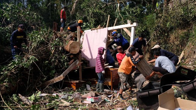 Tim SAR bersama relawan menyingkirkan batang pohon yang tumbang menimpa rumah warga di Beji, Petirejo, Ngadirejo, Temanggung, Jawa Tengah, Sabtu (23/11). [ANTARA FOTO/Anis Efizudin]