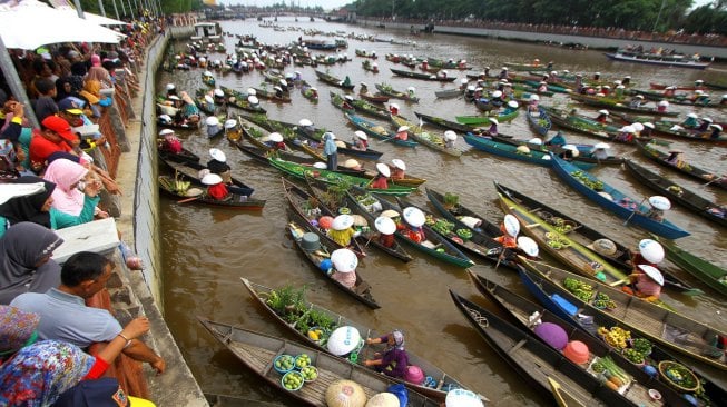 Sejumlah pedagang pasar terapung membagikan sayur dan buah di sungai Martapura, Banjarmasin, Kalimantan Selatan, Minggu (24/11). [ANTARA FOTO/Bayu Pratama S]