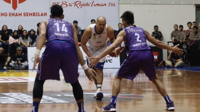 Kapten Satria Muda Pertamina Jakarta, Arki Dikania Wisnu (tengah), mengendalikan bola yang dihadang para pemain Amartha Hangtuah, Fisyaful Amir (kanan) dan M. Lakha Kurniawan, dalam partai final Piala Presiden Bola Basket 2019 di GOR Sritex Arena, Solo, Minggu (24/11). [Antara/Gilang Galiartha]