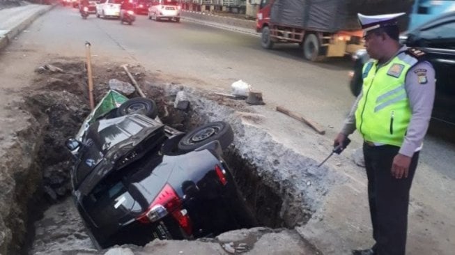 Mobil Terperosok ke Lubang Galian di Jalan DI Panjaitan, Pengemudi Selamat