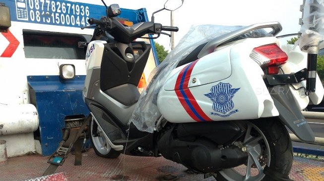 Yamaha Nmax Polisi tengah dinaikkan ke truk gendong untuk menuju lokasi [Suara.com/Manuel Jeghesta Nainggolan].