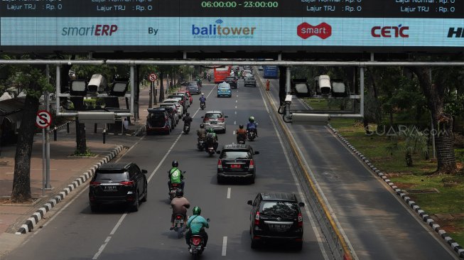 Sejumlah kendaraan melintas di bawah papan informasi Electronic Road Pricing (ERP) di Jalan Medan Merdeka Barat, Jakarta, Selasa (26/11). [Suara.com/Angga Budhiyanto]