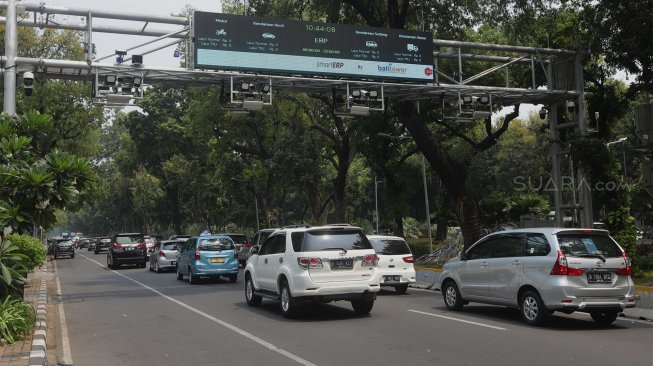 Sejumlah kendaraan melintas di bawah papan informasi Electronic Road Pricing (ERP) di Jalan Medan Merdeka Barat, Jakarta, Selasa (26/11). [Suara.com/Angga Budhiyanto]