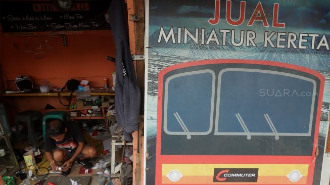 Iskandar (52) menyelesaikan pembuatan miniatur kereta api di kawasan Manggarai, Jakarta, Rabu (27/11).[Suara.com/Angga Budhiyanto]